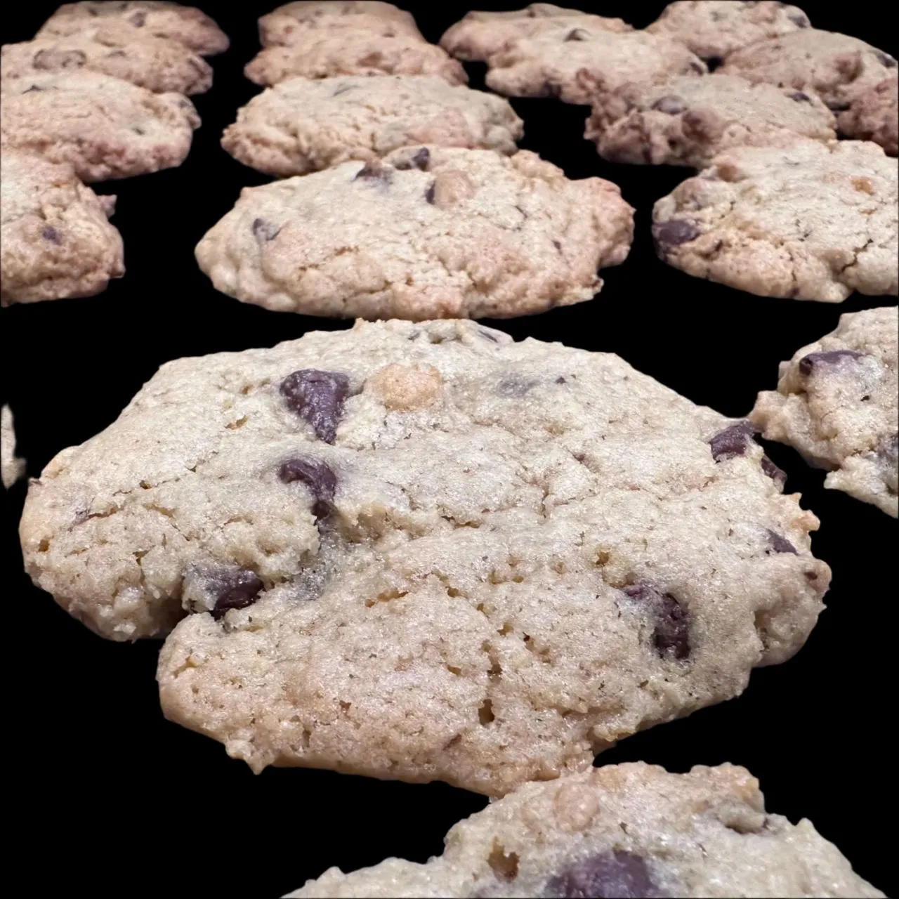 Chocolate chip cookies on a black surface.
