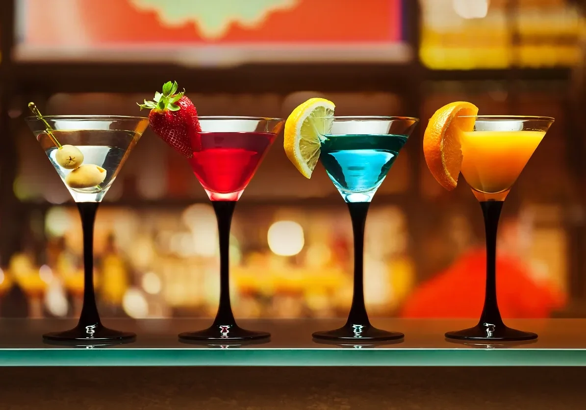 Four colorful cocktails on a bar countertop